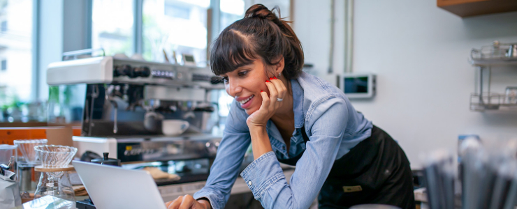 Barista leaning over a laptop