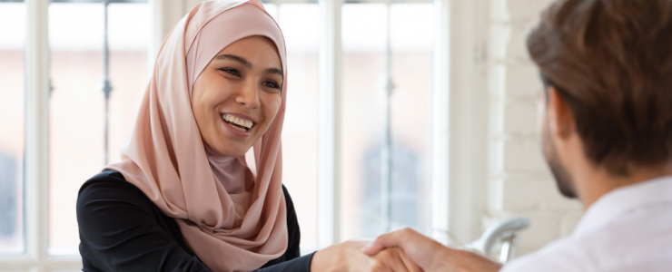 A women shaking a mans hand in a conference room
