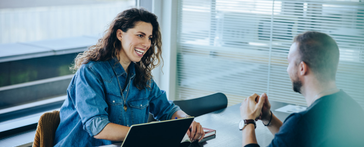 A women in interviewing a man in a conference room