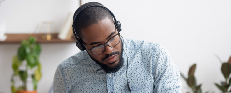 A man with headphones on sitting at a desk