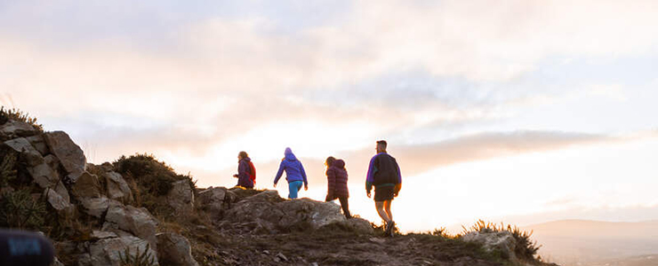 Silhouette of four people hiking on a sunny day