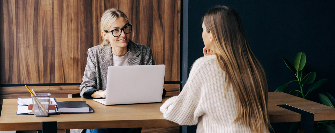 A woman is in her office and talking to another woman