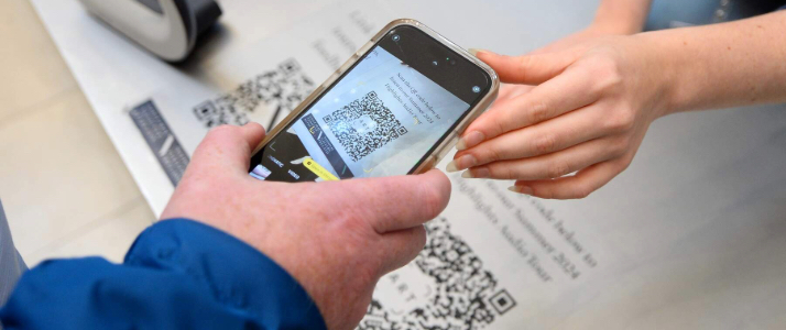 Person taking a picture of a QR code on their phone