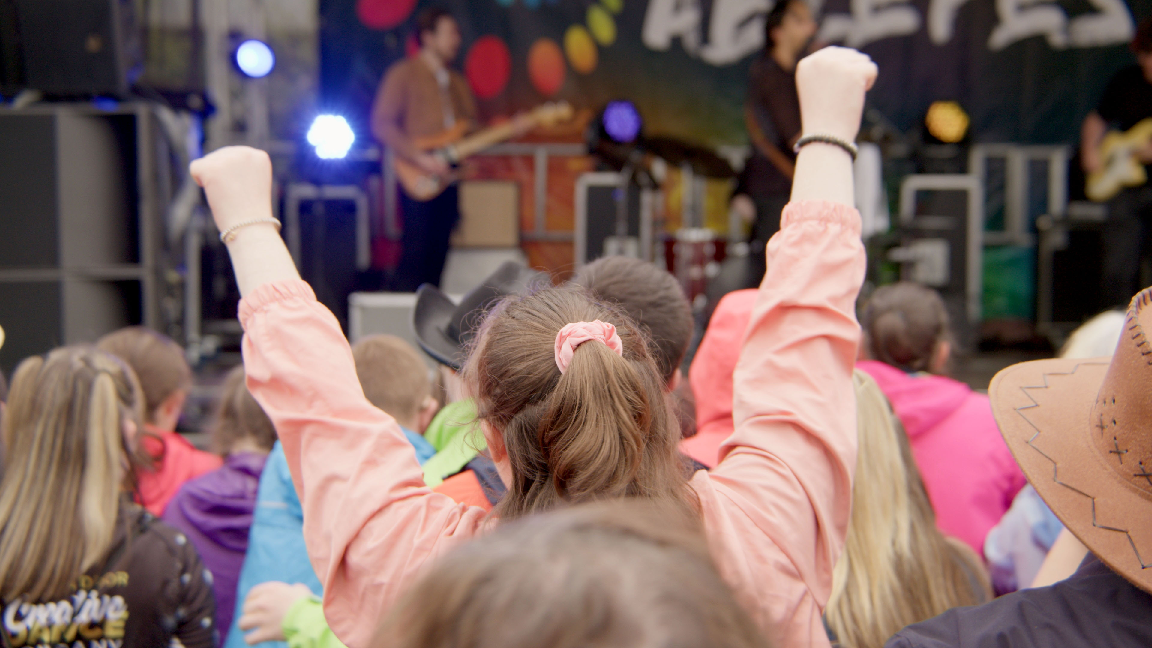 Back of a girls head facing a stage