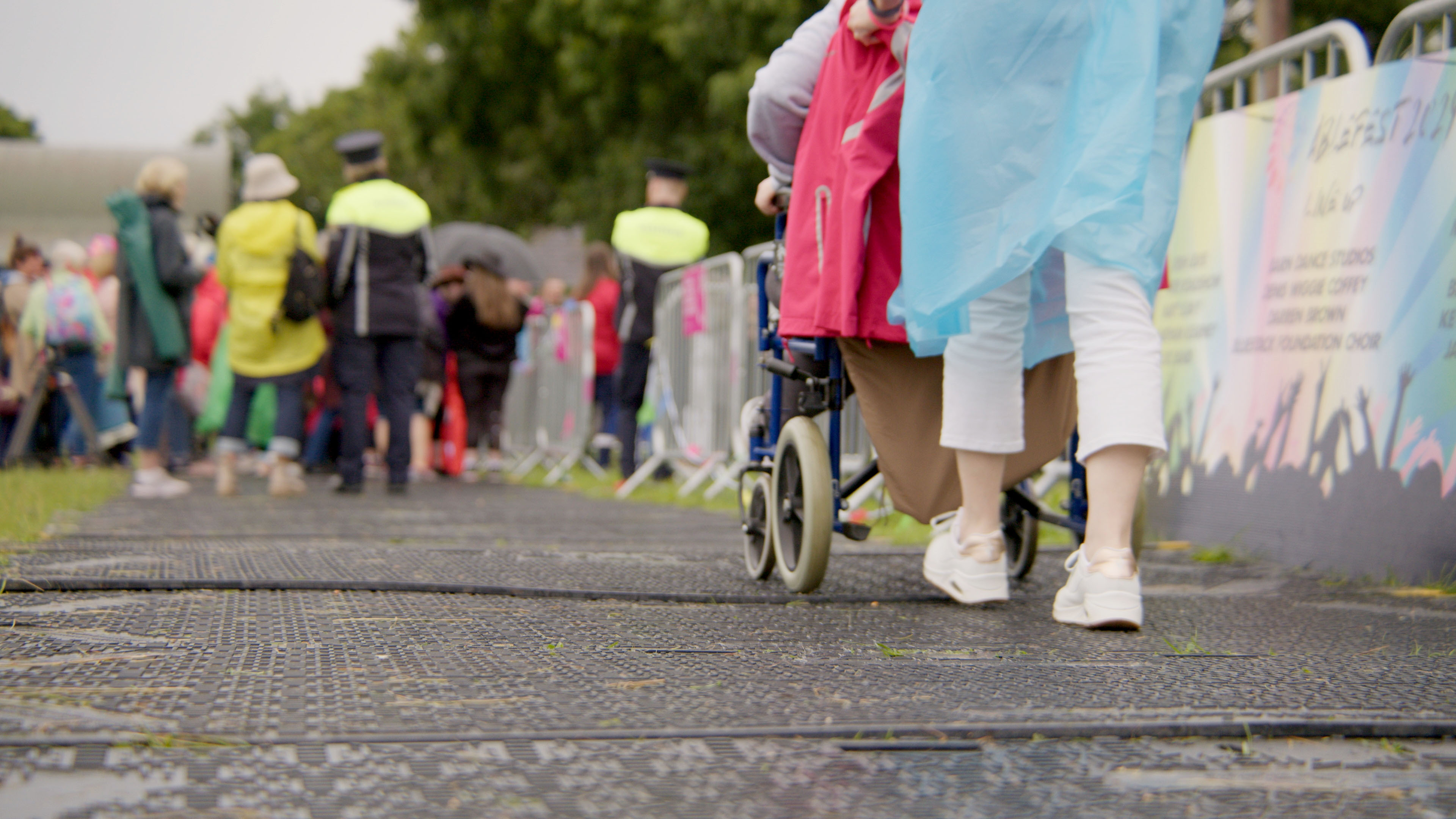Person wheeling a wheelchair going into an outdoor concert
