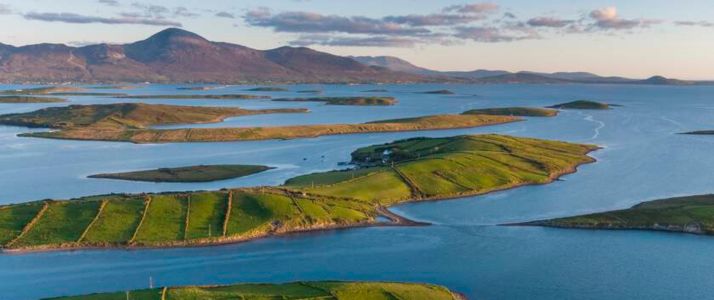 Aerial view of a bay with small islands dotted around, a mountain in the distance