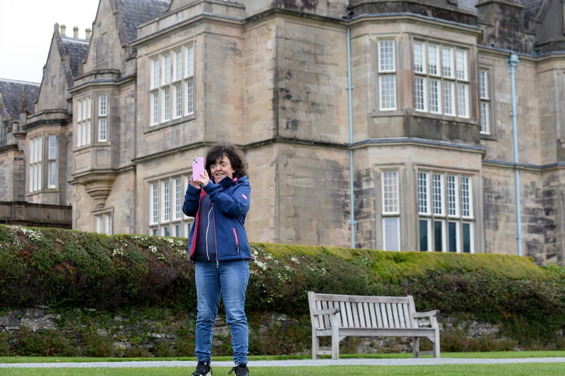 Woman taking a picture in front of a hotel