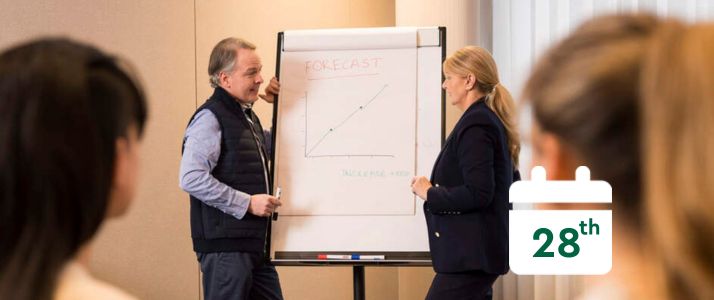 Colleagues standing near whiteboard, calendar icon reads 28th