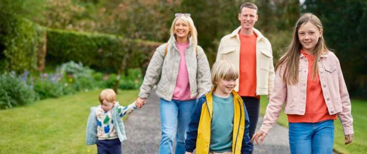 Family, man and woman with three kids, walking in garden