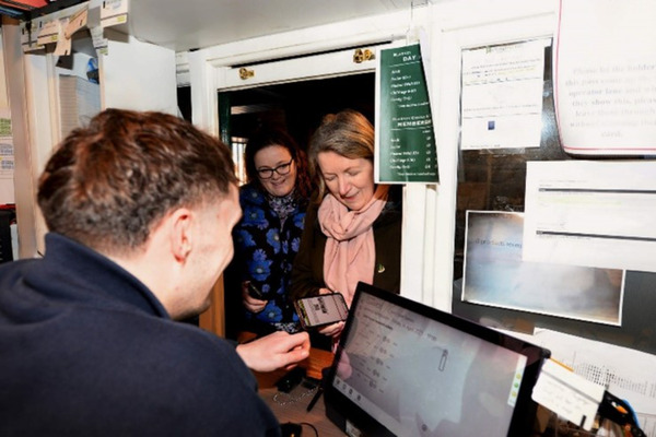 Two customers buying tickets from the ticket booth